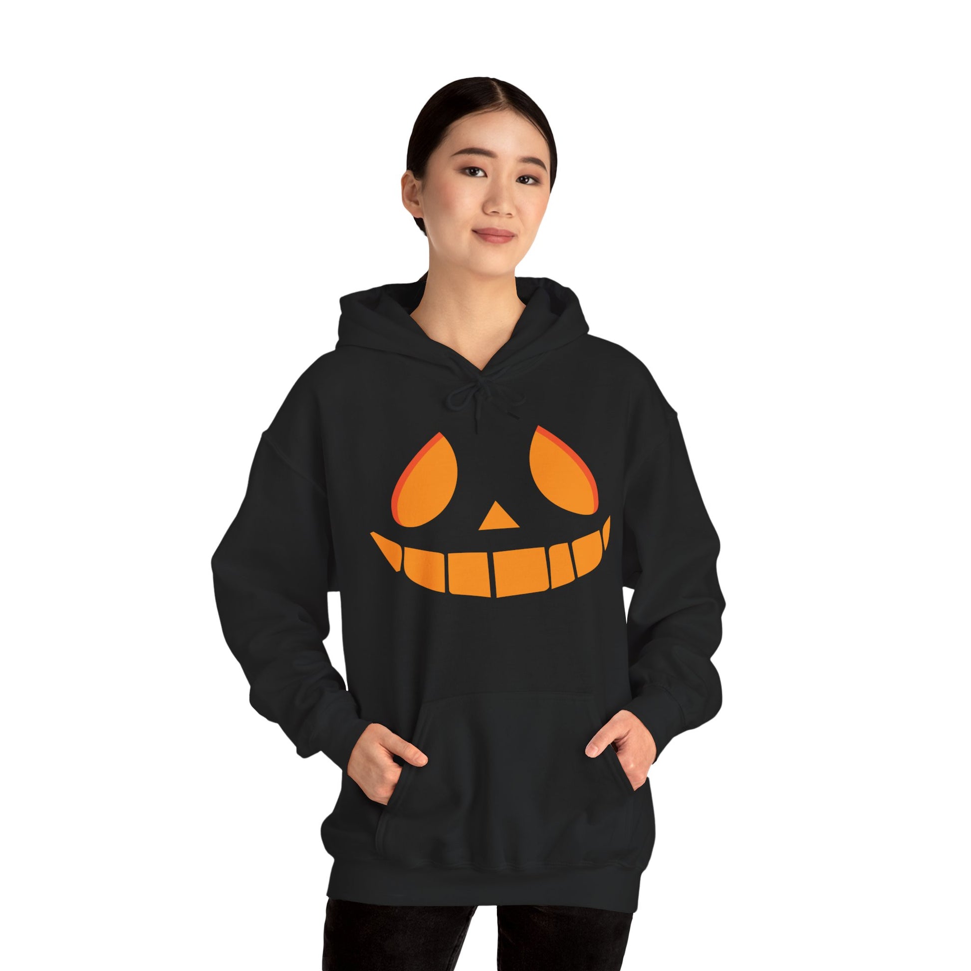 Person wearing a black hoodie with a pumpkin face design on a white background