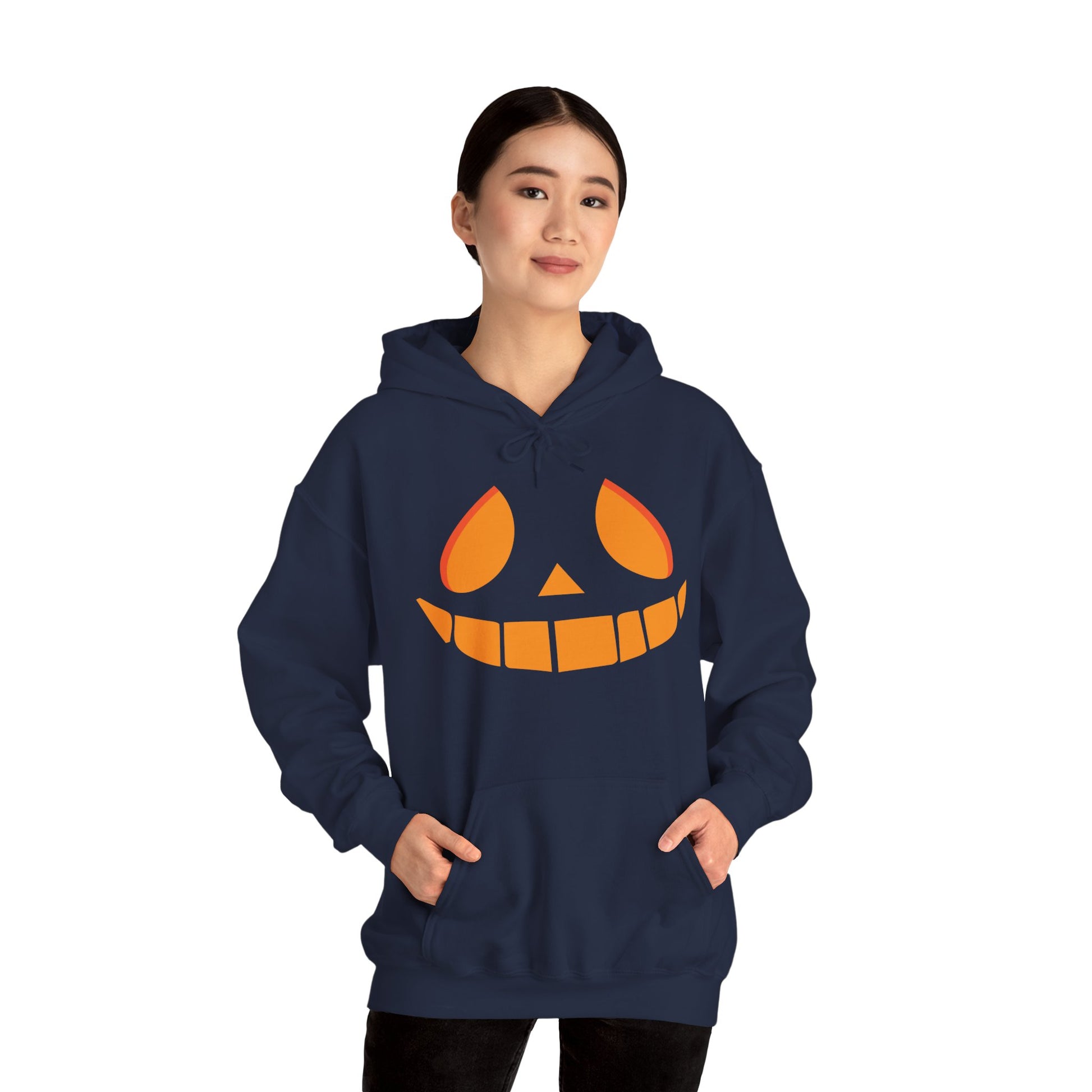 Person wearing a navy blue hoodie with a jack-o'-lantern face design on a white background