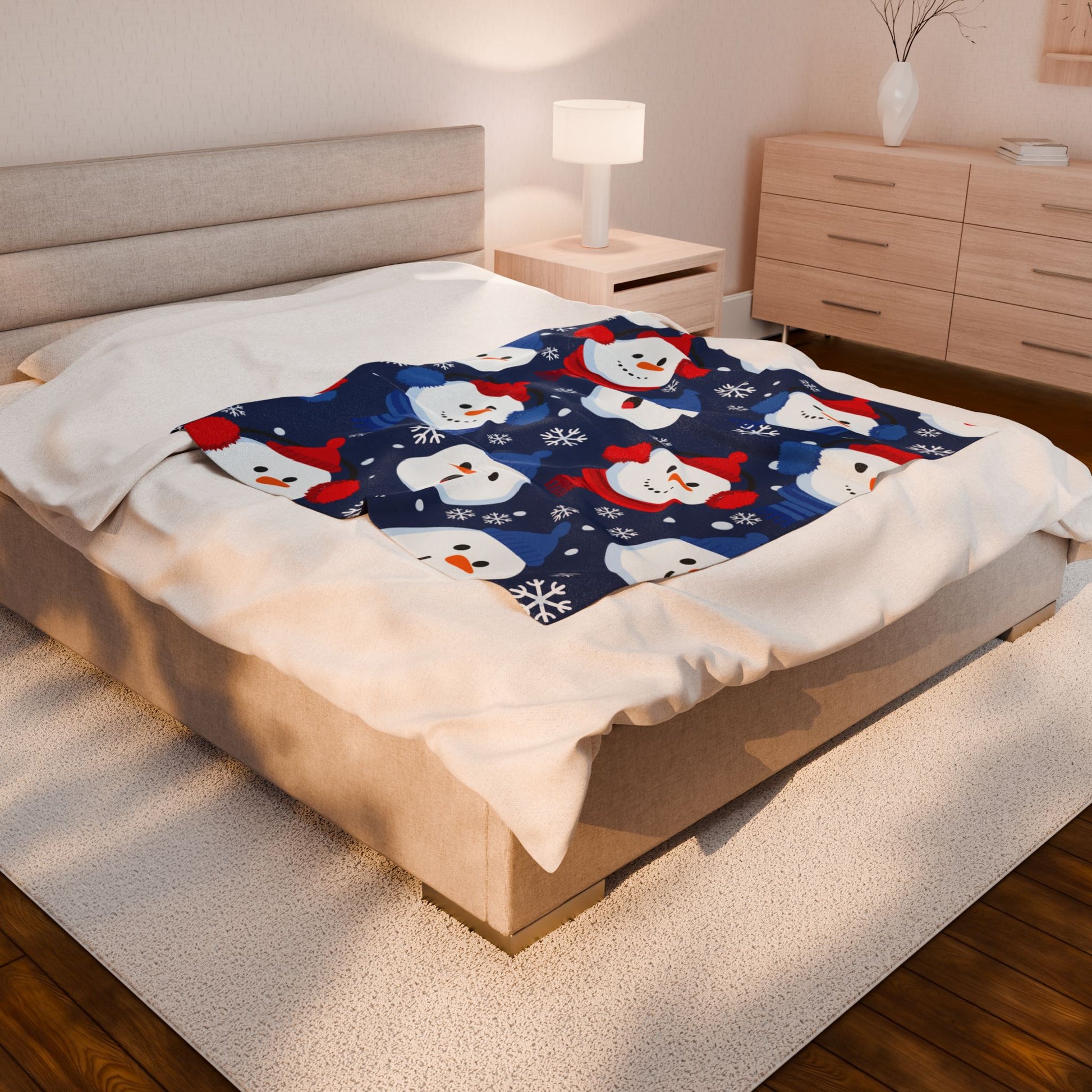 Bed with a snowman patterned blanket in a bedroom setting