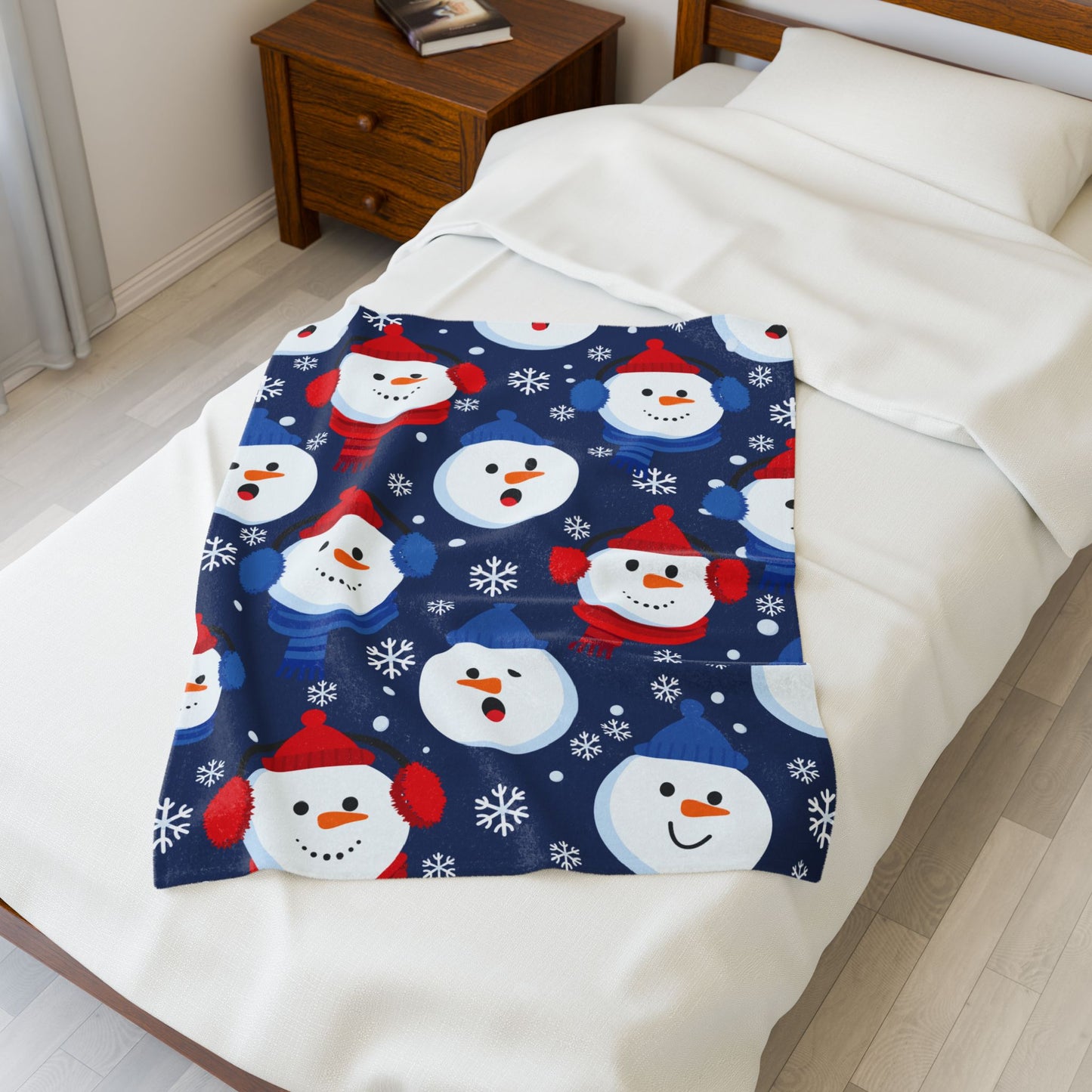 Christmas-themed blanket with snowmen on a bed