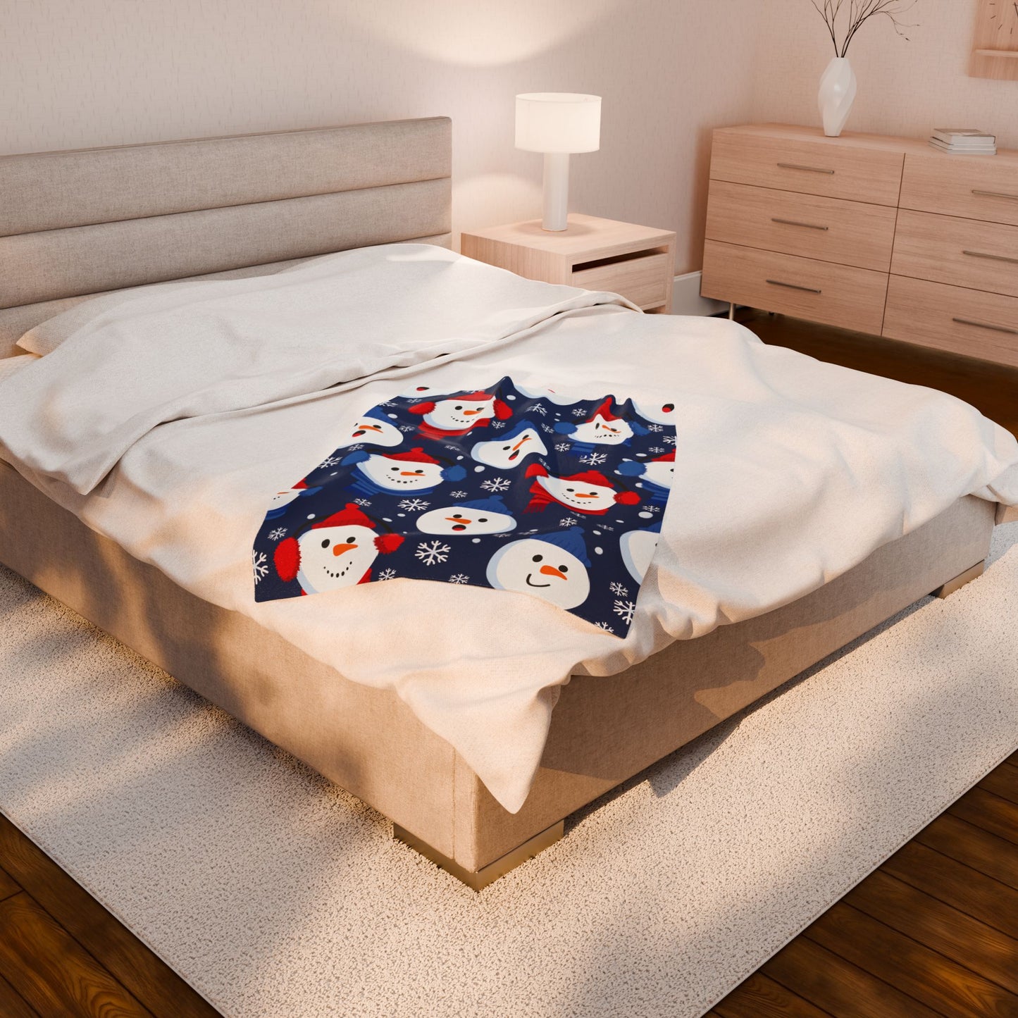 Bed with a snowman patterned blanket in a bedroom setting