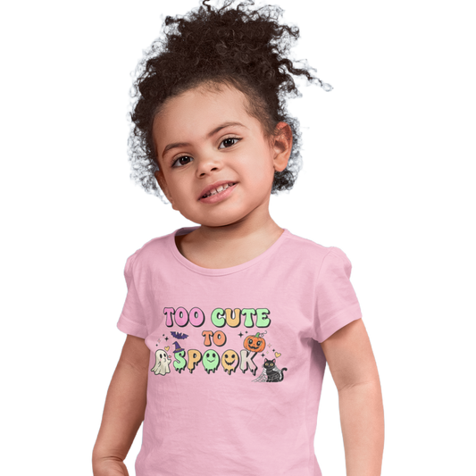 Child wearing a pink t-shirt with 'Too Cute to Spook' text and graphics on a white background